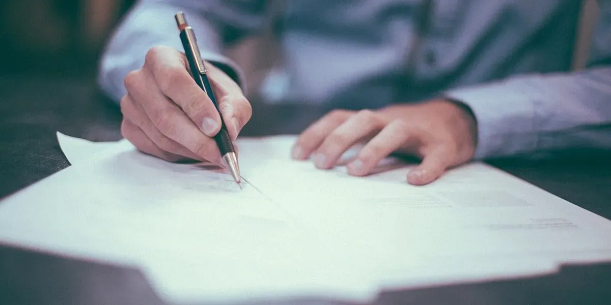 Signature d'un contrat d'assurance prévoyance obsèques avec un stylo.