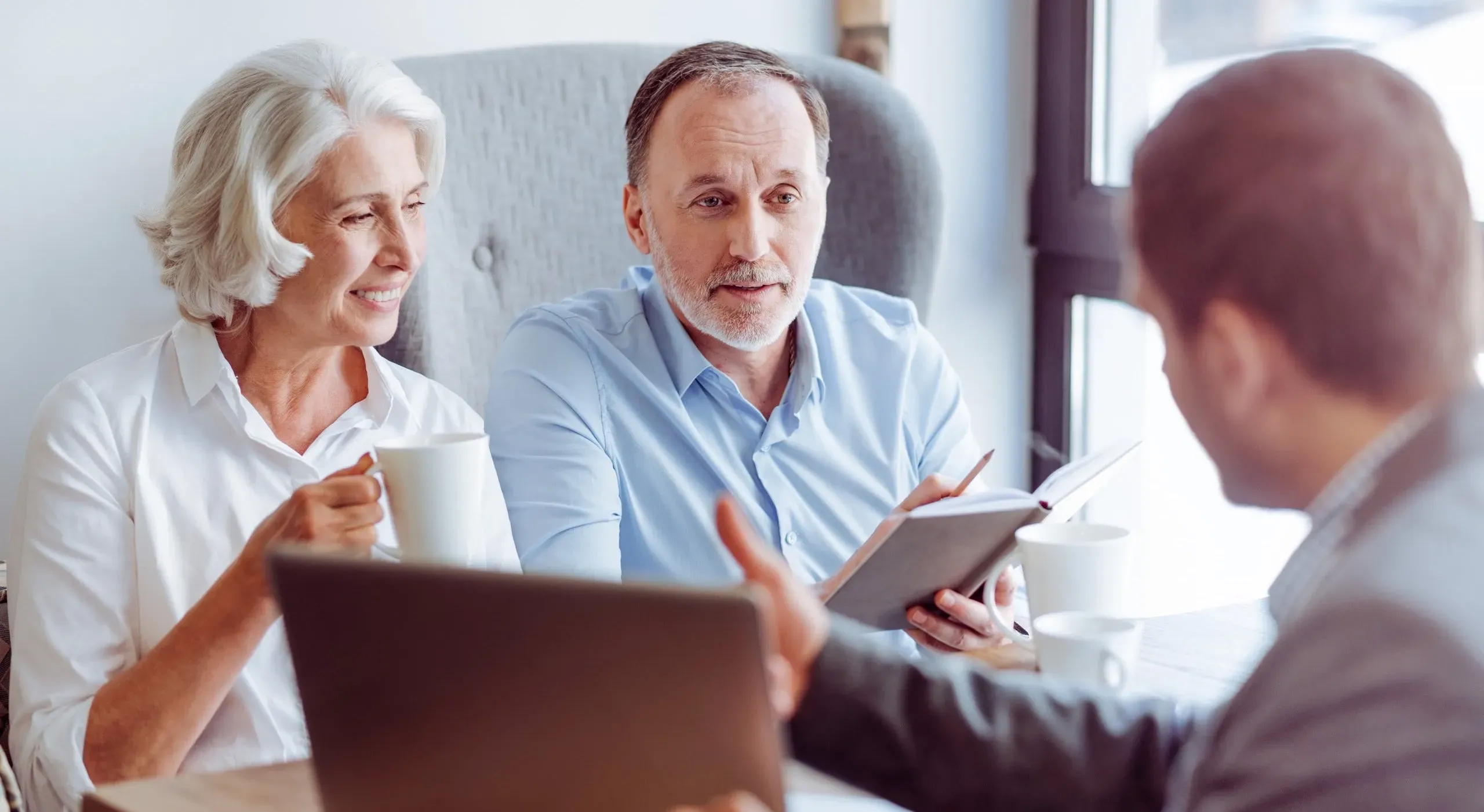Couple senior en rendez-vous pour préparer un contrat de prévoyance obsèques.